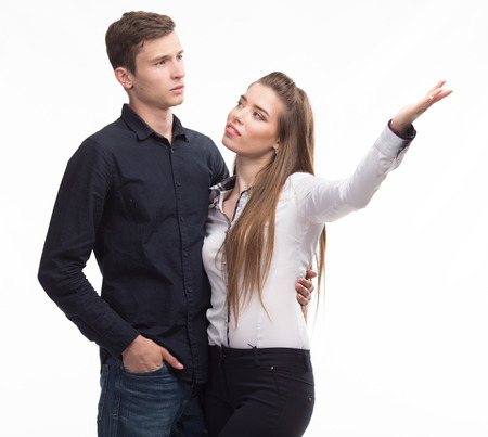 Young happy couple showing presentation pointing on placard overの写真素材