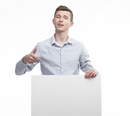 Young happy man showing presentation, pointing on placard over gの写真素材