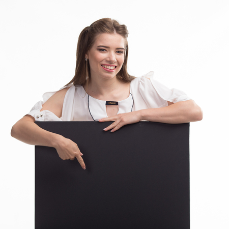 Young happy woman showing presentation, pointing on placard overの写真素材