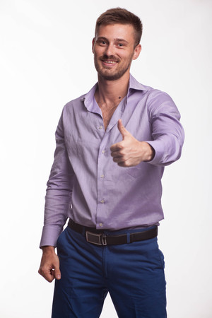 Young happy man portrait of a confident businessman showing by hands on a gray background. Ideal for banners, registration forms, presentation, landings, presenting concept.の写真素材