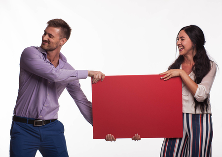 Young happy woman portrait of a confident businesswoman showing presentation, pointing placard gray background. Ideal for banners, registration forms, presentation, landings, presenting concept.の写真素材