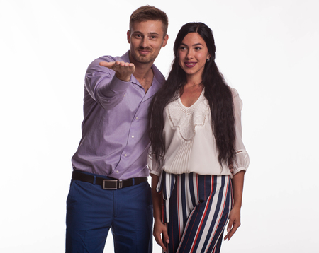 Young pry woman portrait of a confident businesswoman showing by hands on a gray background. Ideal for banners, registration forms, presentation, landings, presenting concept.の写真素材