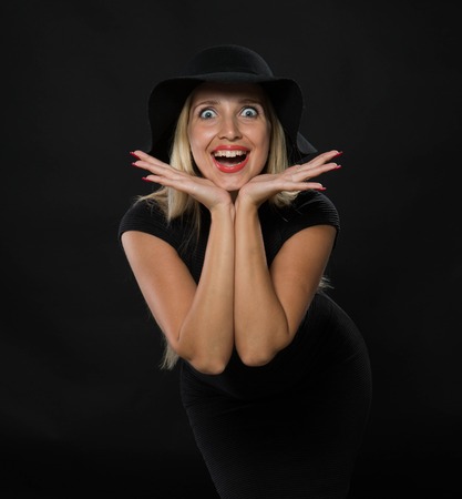 Young happy woman portrait of a confident businesswoman showing by hands on a black background. Ideal for banners, registration forms, presentation, landings, presenting conceptの写真素材