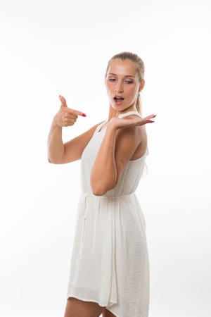 Young surprised woman portrait of a confident businesswoman showing by hands on a gray background. Ideal for banners, registration forms, presentation, landings, presenting conceptの写真素材