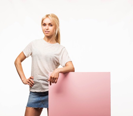 Young happy woman portrait of a confident businesswoman showing presentation, pointing placard gray background. Ideal for banners, registration forms, presentation, landings, presenting concept.の写真素材