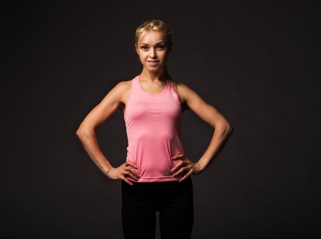 Young  confident woman portrait of a businesswoman showing by hands on a black background. Ideal for banners, registration forms, presentation, landings, presenting conceptの写真素材