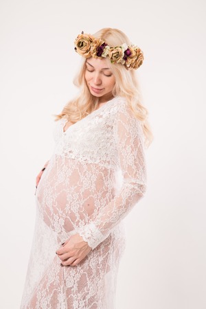 Young mom tenderly stroked pregnant belly with unborn baby.の写真素材