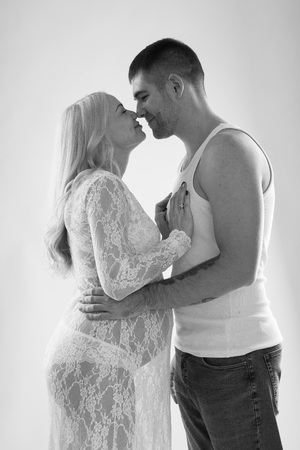 Beautiful pregnant couple in love on the background. Hands of husband on the tummy of his pregnant wife. Young man tenderly stroked pregnant belly of his wife. Husband kissing pregnant belly.の写真素材