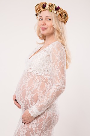 Happy pregnant young woman in love on the background. Hands on the tummy. Young mom tenderly stroked pregnant belly with unborn baby.の写真素材