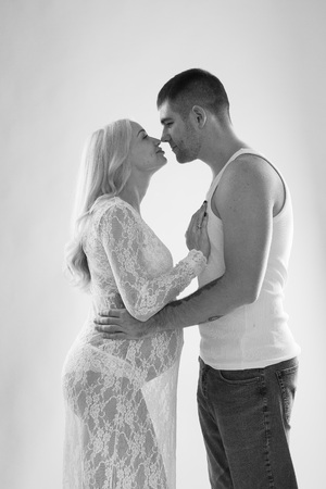Beautiful pregnant couple in love on the background. Hands of husband on the tummy of his pregnant wife. Young man tenderly stroked pregnant belly of his wife. Husband kissing pregnant belly.の写真素材