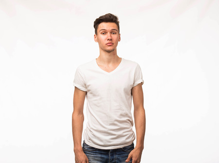 Young serious man portrait of a confident businessman stands straight on a gray background. Ideal for banners, registration forms, presentation, landings, presenting concept.の写真素材