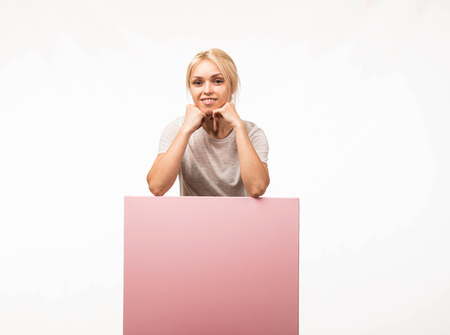 Young confident woman portrait of a confident businesswoman showing presentation, pointing placard gray background. Ideal for banners, registration forms, presentation, landings, presenting concept.の写真素材