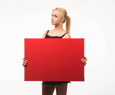Young confident woman portrait of a confident businesswoman showing presentation, pointing placard gray background. Ideal for banners, registration forms, presentation, landings, presenting concept.の写真素材