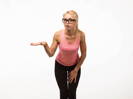Young surprised woman portrait of a confident businesswoman showing by hands on a gray background. Ideal for banners, registration forms, presentation, landings, presenting conceptの写真素材