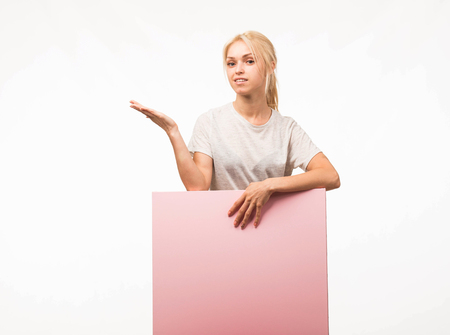 Young confident woman portrait of a confident businesswoman showing presentation, pointing placard gray background. Ideal for banners, registration forms, presentation, landings, presenting concept.の写真素材