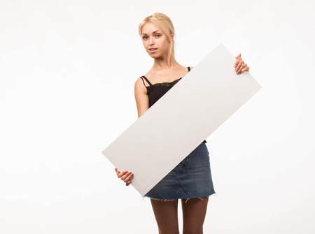 Young confident woman portrait of a confident businesswoman showing presentation, pointing placard gray background. Ideal for banners, registration forms, presentation, landings, presenting concept.の写真素材