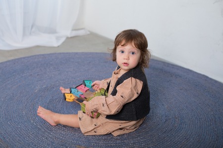 Little happy girl playing with toy on floor. Kindergarten.の写真素材