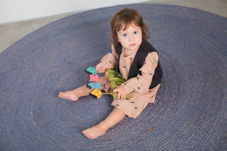 Little happy girl playing with toy on floor. Kindergarten.の写真素材