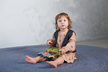 Little happy girl playing with toy on floor. Kindergarten.の写真素材