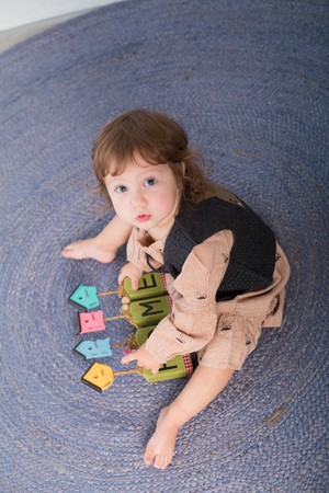 Little happy girl playing with toy on floor. Kindergarten.の写真素材