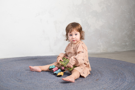 Little happy girl playing with toy on floor. Kindergarten.の写真素材