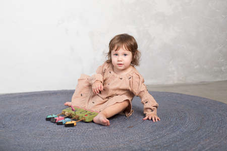Little happy girl playing with toy on floor. Kindergarten.の写真素材