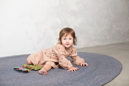 Little happy girl playing with toy on floor. Kindergarten.の写真素材
