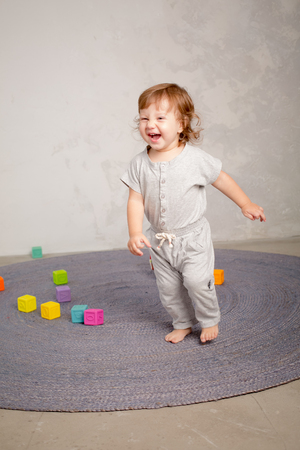 Little happy girl playing with toy on floor. Kindergarten.の写真素材