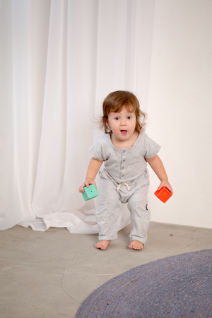 Little happy girl playing with toy on floor. Kindergarten.の写真素材