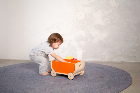 Little happy girl playing with toy on floor. Kindergarten.の写真素材