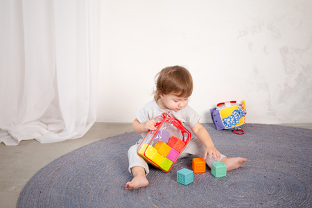 Little happy girl playing with toy on floor. Kindergarten.の写真素材