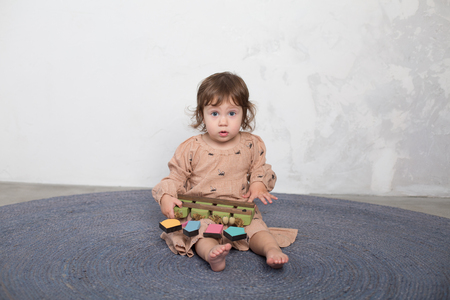 Little happy girl playing with toy on floor. Kindergarten.の写真素材
