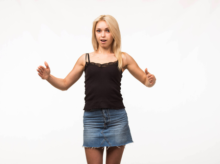 Young confident woman portrait of a businesswoman showing by hands on a gray background. Ideal for banners, registration forms, presentation, landings, presenting conceptの写真素材