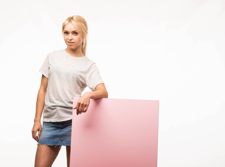 Young confident woman portrait of a businesswoman showing presentation, pointing placard gray background. Ideal for banners, registration forms, presentation, landings, presenting concept.の写真素材