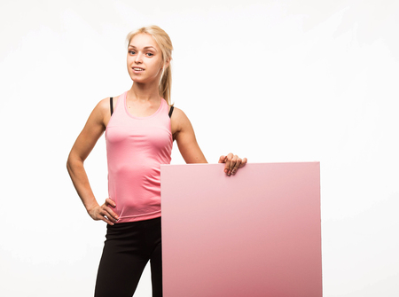 Young confident woman portrait of a businesswoman showing presentation, pointing placard gray background. Ideal for banners, registration forms, presentation, landings, presenting concept.の写真素材