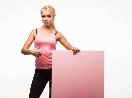 Young confident woman portrait of a businesswoman showing presentation, pointing placard gray background. Ideal for banners, registration forms, presentation, landings, presenting concept.の写真素材