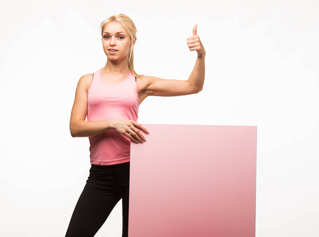 Young confident woman portrait of a businesswoman showing presentation, pointing placard gray background. Ideal for banners, registration forms, presentation, landings, presenting concept.の写真素材