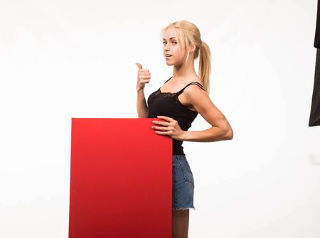 Young sexy woman portrait of a confident woman showing presentation, pointing placard gray background.の写真素材