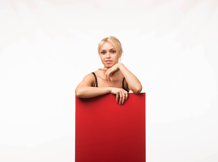 Young glad woman portrait of a confident businesswoman showing presentation, pointing placard gray background. Ideal for banners, registration forms, presentation, landings, presenting concept.の写真素材