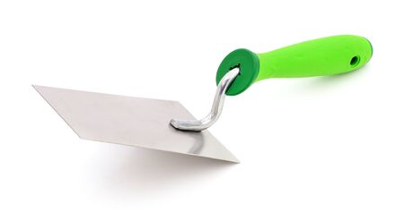 Metal trowel with a green plastc handly on a white background.の写真素材