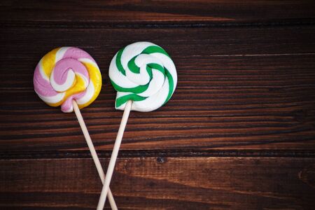 Round delicious candy on a wooden background. The concept of childhood and food.の写真素材