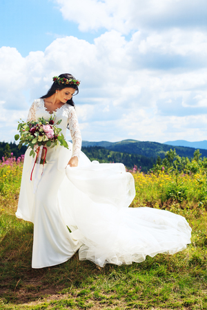 Happy bride with a bouquet in the mountains. The concept of marriage and lifestyle.の写真素材