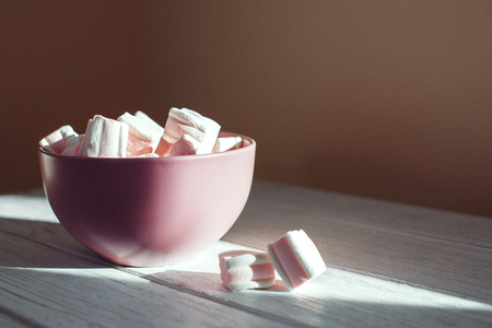 Marshmellow in a bowl on a white table. The concept of food.の写真素材