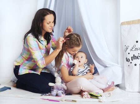 Mom plays with two daughters. The concept of family and lifestyle.の写真素材