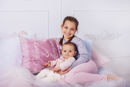 sister hugs little sister. The concept of childhood and education.の写真素材
