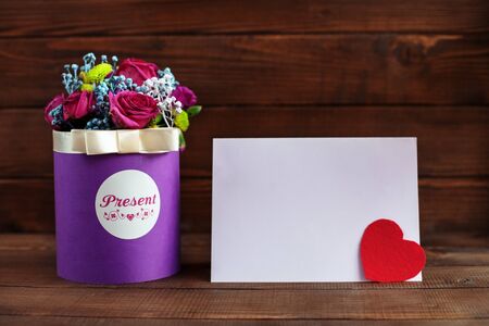 Beautiful purple flowers in a box on a wooden background. Conception holiday, Valentine's Day.の写真素材