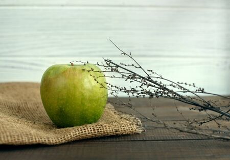 Juicy green apple on a wooden table. The concept of healthy eating and vegetarianism.の写真素材