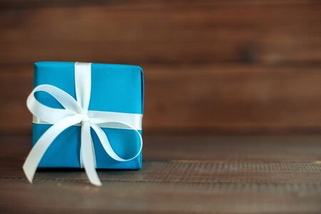 Blue gift with ribbon on a wooden background. Concept of holiday, birthday, Easter, March 8..の写真素材