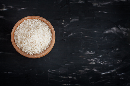 Polished rice in a wooden bowl. The concept of healthy eating and vegetarianism.の写真素材