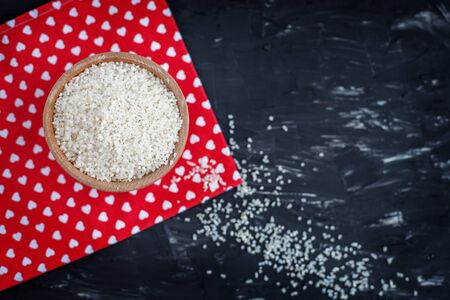 Bowl of raw rice on a red napkin. The concept of healthy eating and vegetarianism.の写真素材